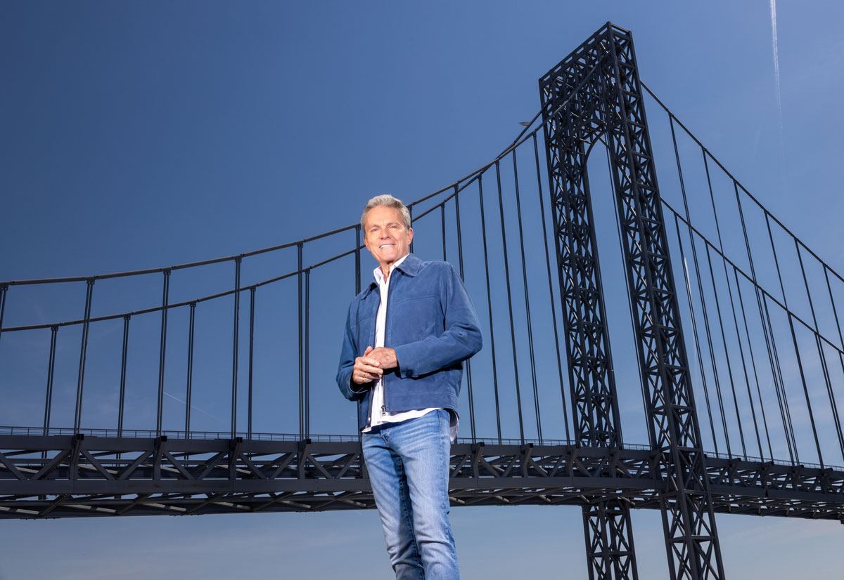 Alfons Haider vor der Verrazzano Narrows Bridge des Bühnenbildes von Saturday Night Fever.